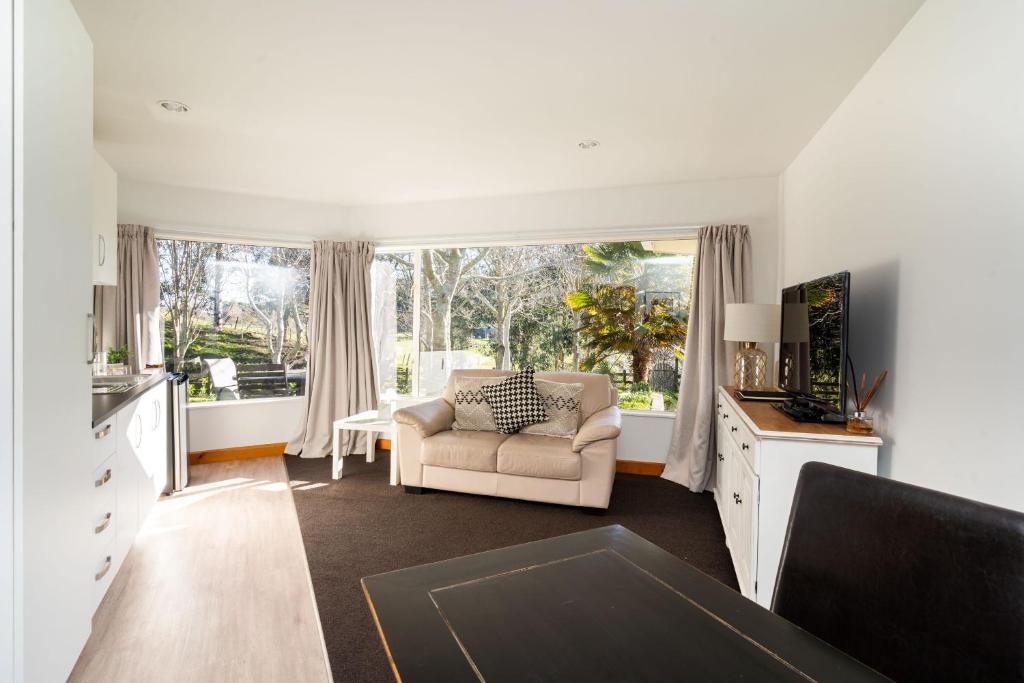 a living room with a couch and a window at Country Apartment in Paraparaumu