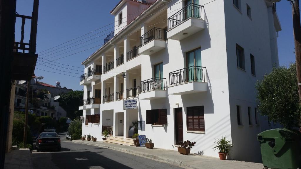 biały budynek z balkonami przy ulicy w obiekcie Pissouriana hotel Apartments w mieście Pissouri
