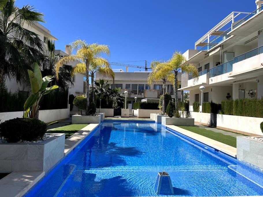 une piscine en face d'un bâtiment dans l'établissement Apartamentos Gran Sol con jardin, à Ciudad Quesada