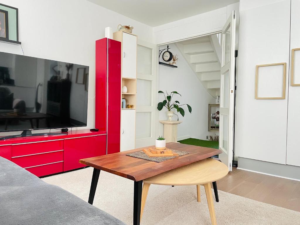 a living room with a wooden table and a red cabinet at Your Perfect Aarhus Staycation in Aarhus
