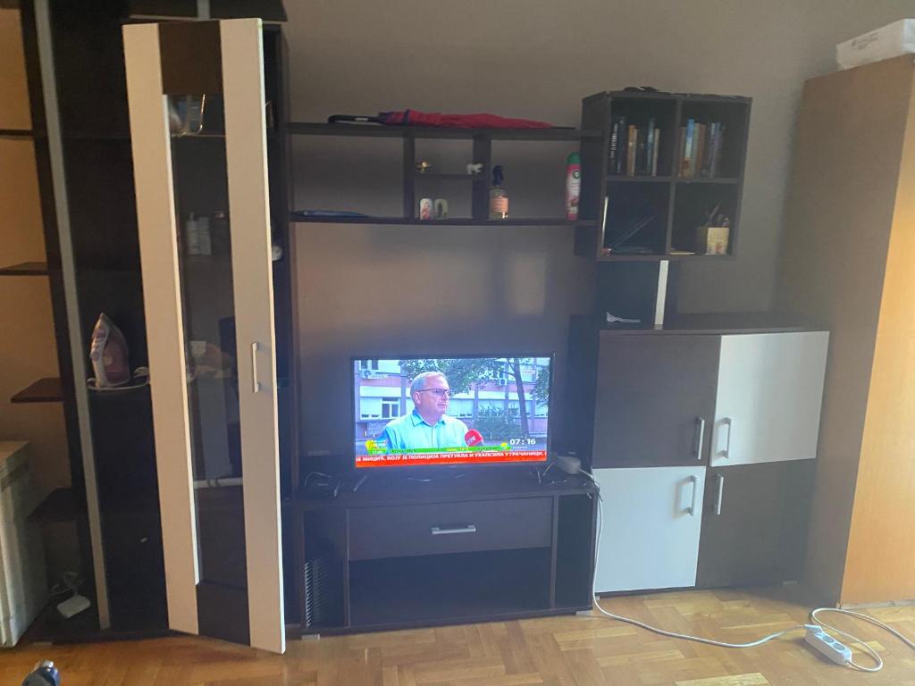 a tv with a man on it in a living room at Stan blizu izlaza na autoput in Mali Mokri Lug