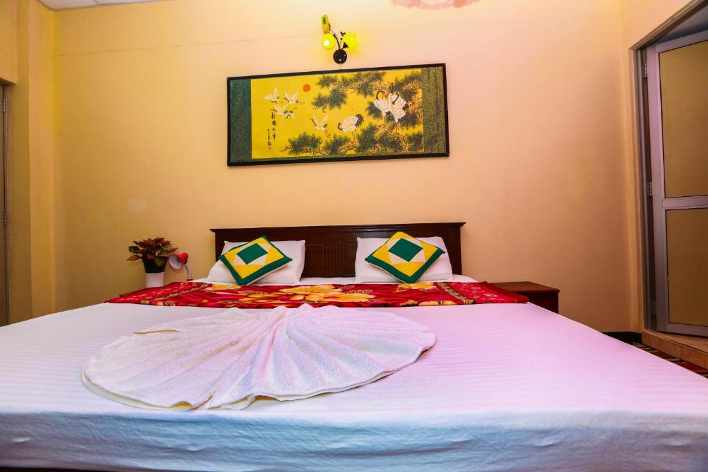 una camera da letto con un grande letto con lenzuola bianche di Hotel Kingland a Ruwanwella