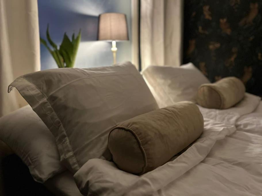 een wit bed met kussens en een deken erop bij Rauhallinen kaksio Urpolassa in Mikkeli