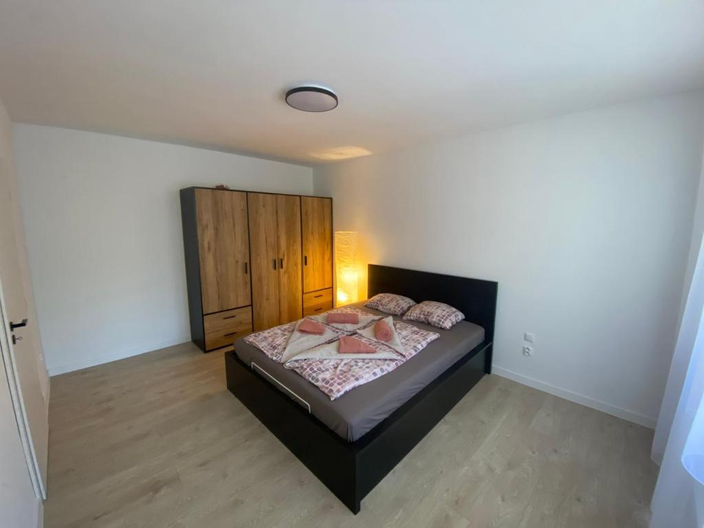 a bedroom with a bed and a wooden cabinet at Apartmán Kristína in Štúrovo