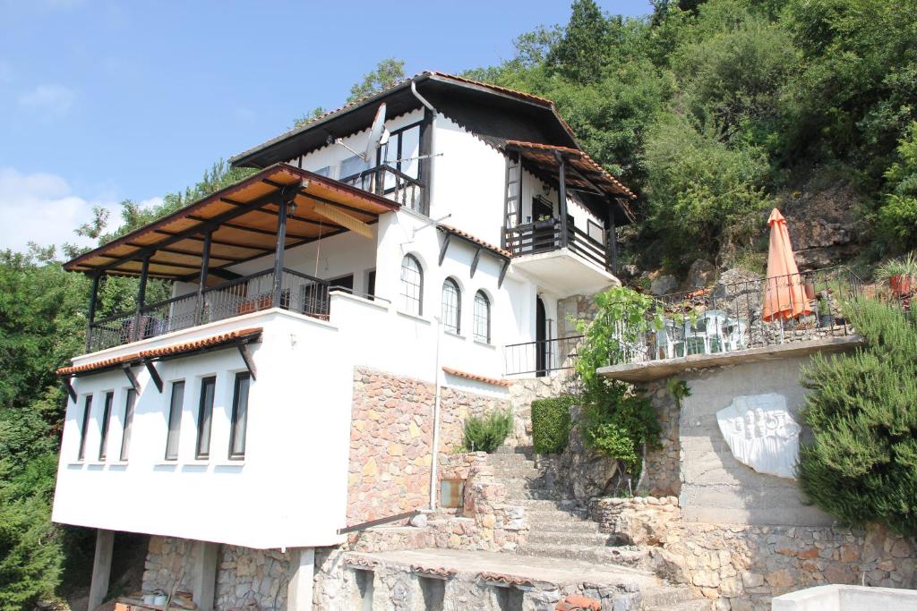 Biały dom z parasolką na wzgórzu w obiekcie Villa Panorama Struga, Elen Kamen w mieście Struga