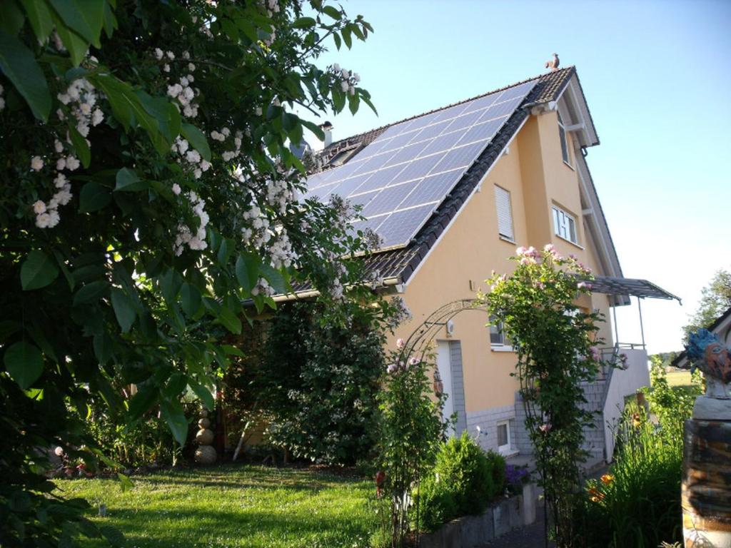 una casa con paneles solares en el techo en Ferienwohnung am Reitplatz, en Neuried