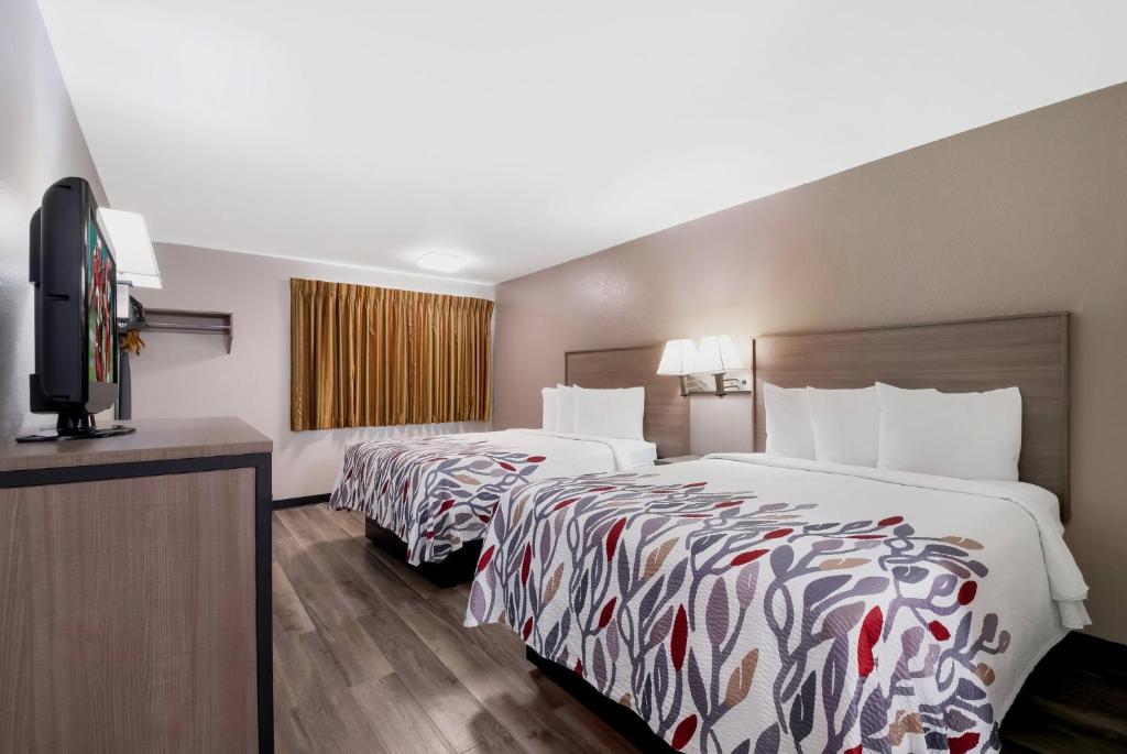 a hotel room with two beds and a flat screen tv at Red Roof Inn Chattanooga - Lookout Mountain in Chattanooga