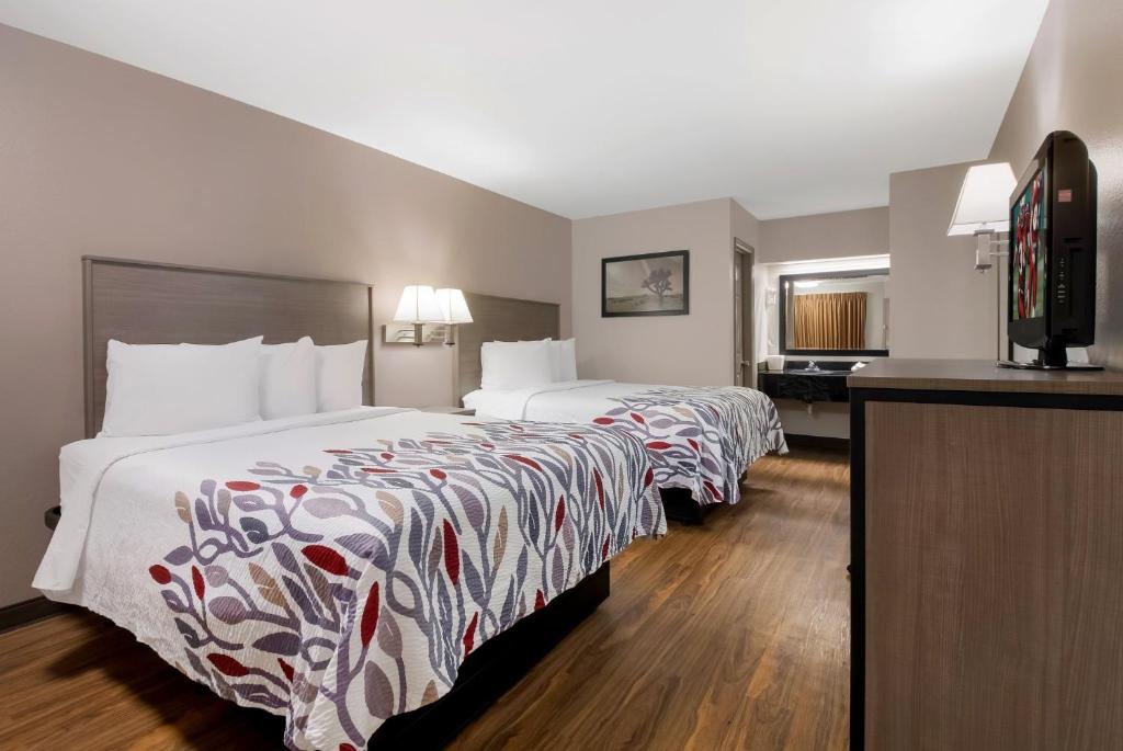 a hotel room with two beds and a flat screen tv at Red Roof Inn Chattanooga - Lookout Mountain in Chattanooga