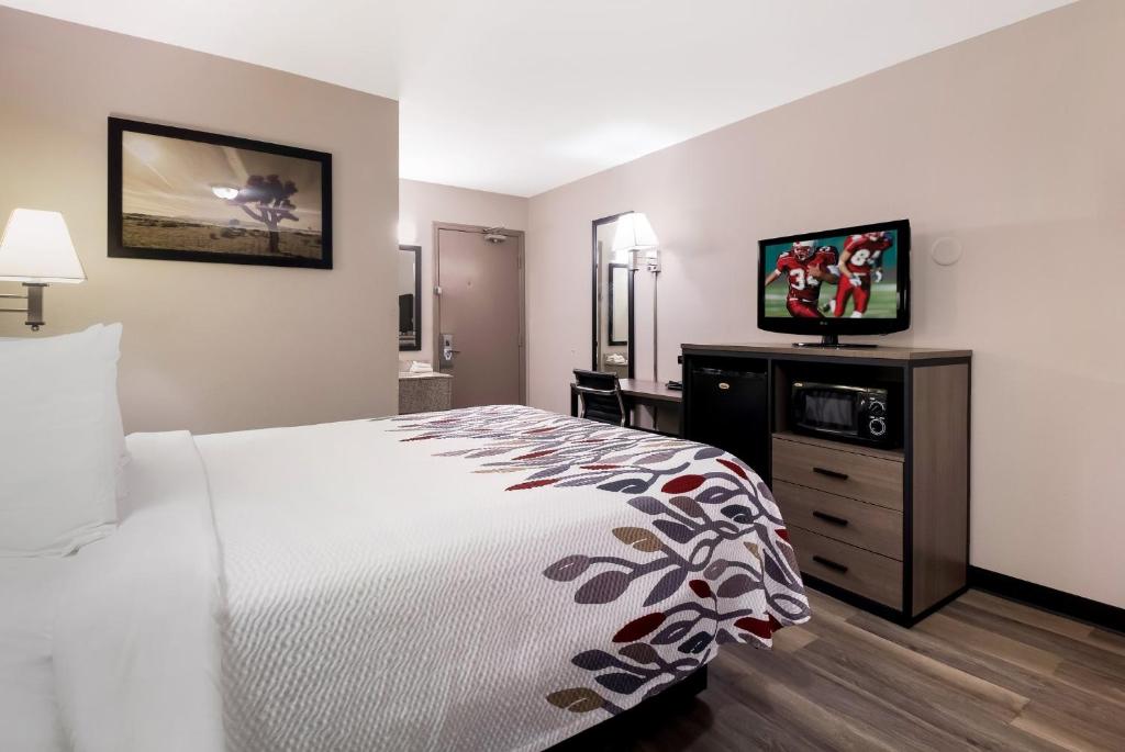 a hotel room with a bed and a flat screen tv at Red Roof Inn Chattanooga - Lookout Mountain in Chattanooga