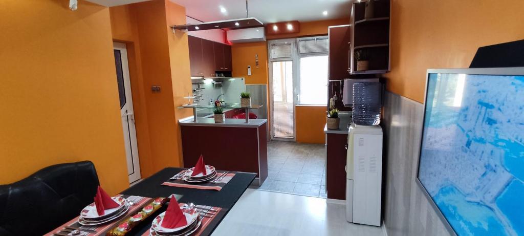 eine Küche mit einem Tisch mit roten Hüten darauf in der Unterkunft Апартамент ВИСАИ in Blagoewgrad