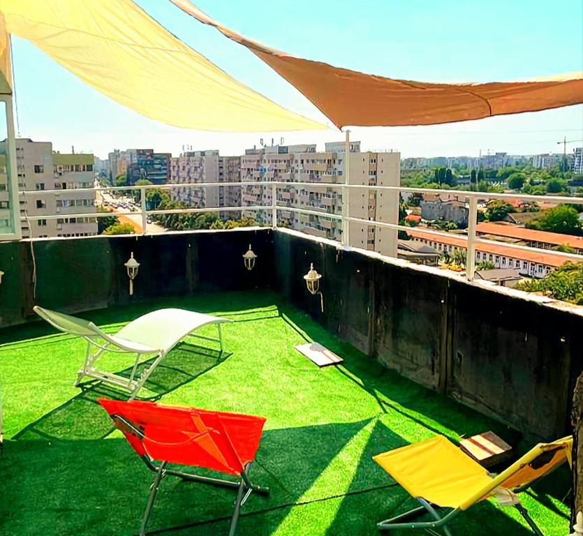 d'un balcon avec des chaises et une pelouse sur le toit. dans l'établissement PTM One, à Bucarest