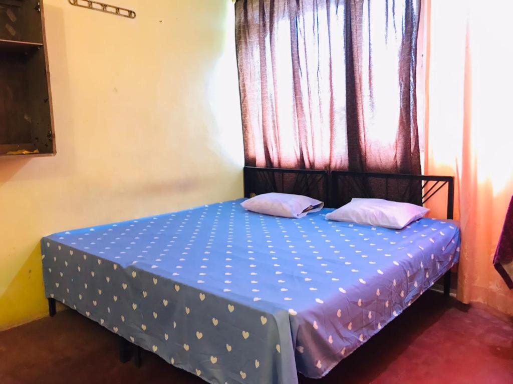 - une chambre avec un lit bleu et des oreillers roses dans l'établissement Coca Cola Hostel Malabe, à Malabe