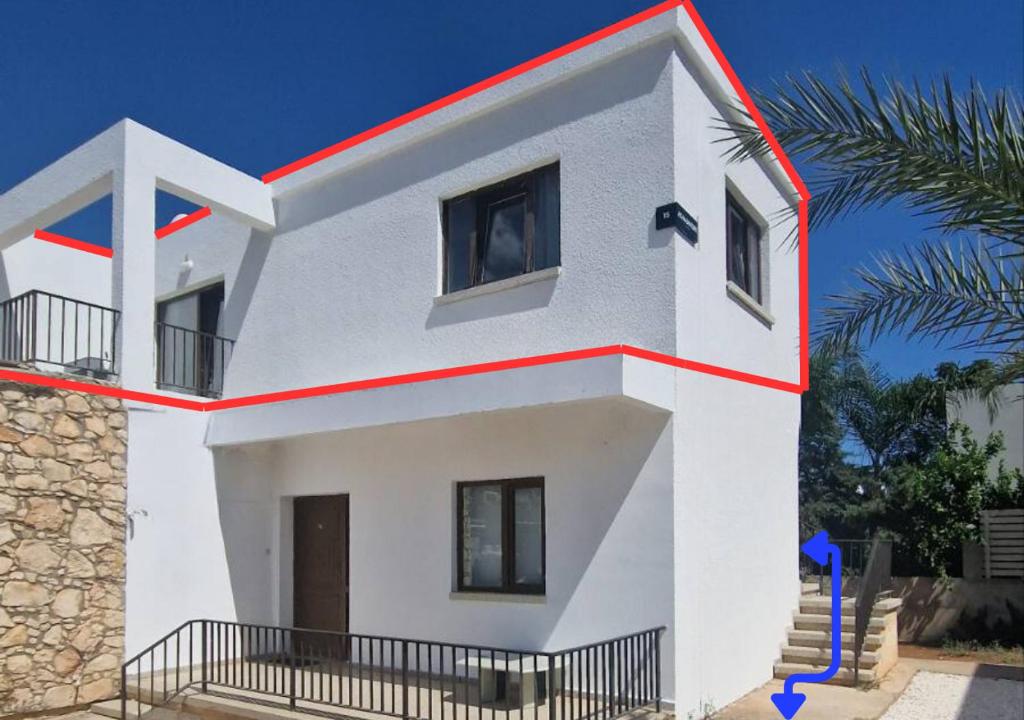 a white house with a red stripe on it at Adamandri Lodge - Prime Location in Ayia Napa