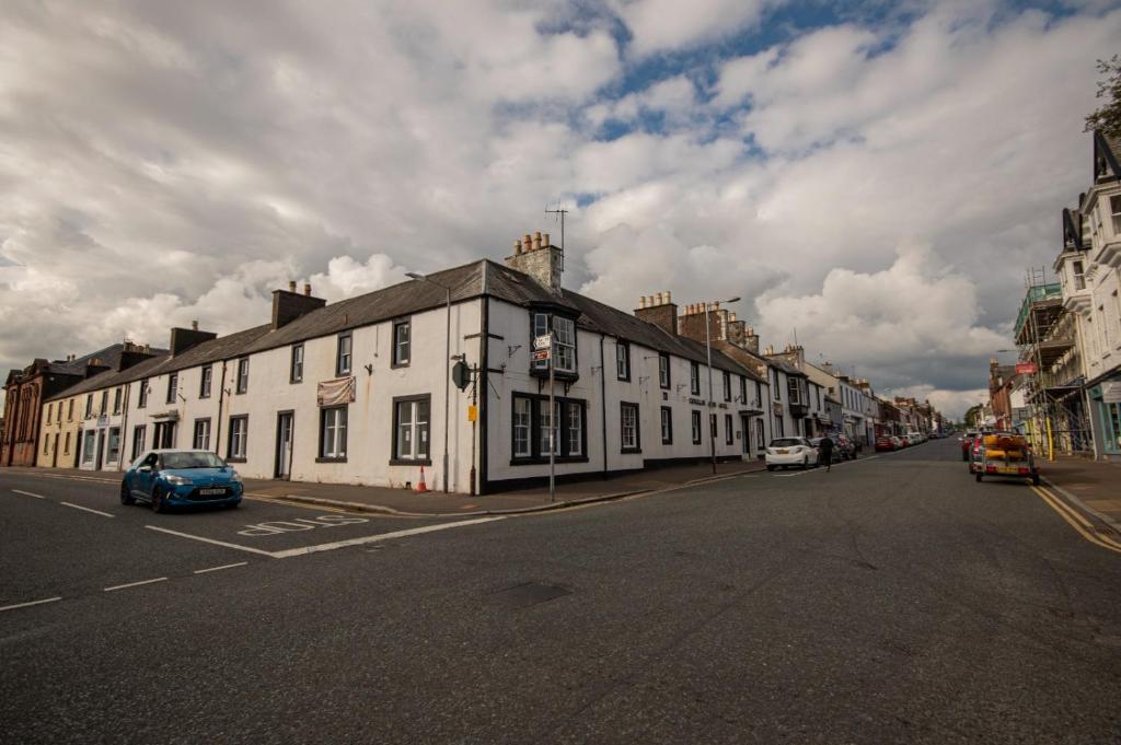 uma rua com um edifício branco na lateral da estrada em Douglas Arms Hotel em Castle Douglas