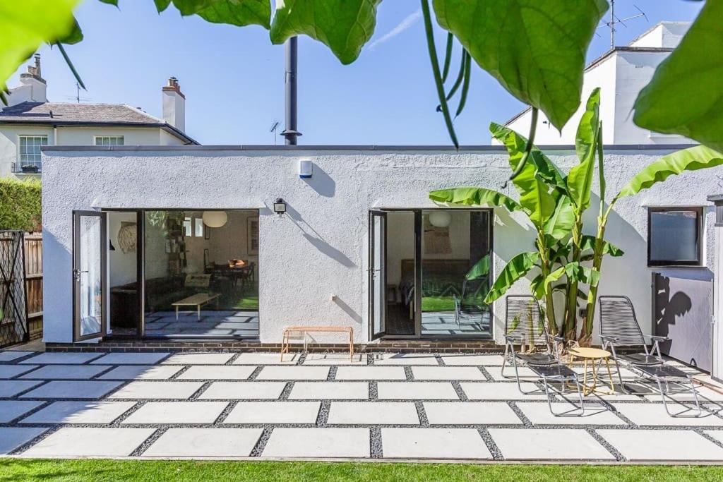 una casa con un patio con 2 sillas en Gorgeous 1BD Balearic-style home with Gardens en Cheltenham