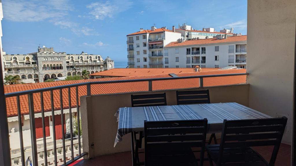 - un balcon avec une table, des chaises et des bâtiments dans l'établissement Appartement 3 pièces au coeur d'Hendaye plage, à Hendaye
