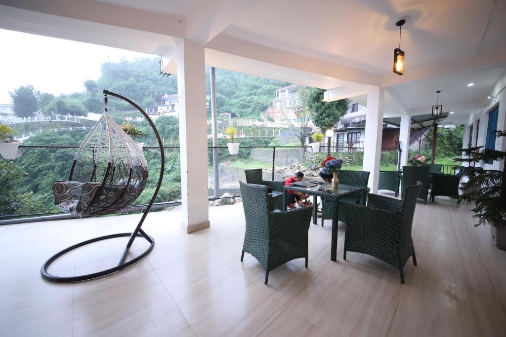 a room with a table and chairs and a swing at PerfectPlus Mussoorie in Mussoorie