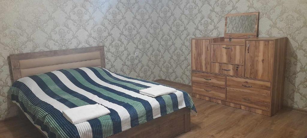 a bedroom with a bed and a wooden dresser at Marekhi guest house in Sagarejo