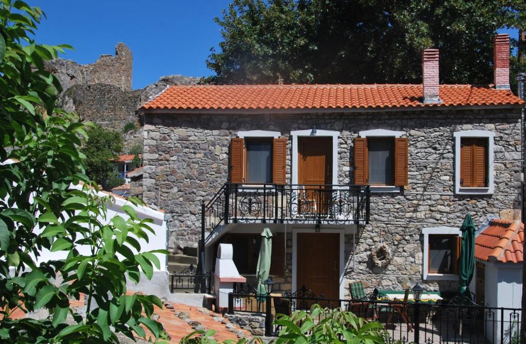 an old stone house with a balcony on a street at Chora Samothrakis, House with courtyard in Samothráki