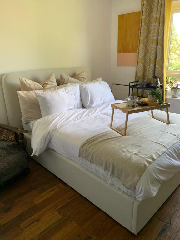 a white bed with a table on top of it at Light & Airy Oasis in South Norwood