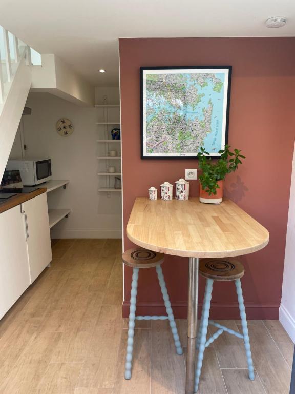 - une cuisine avec une table et deux tabourets dans une pièce dans l'établissement Duplex confort et jardin charmant, à Nantes