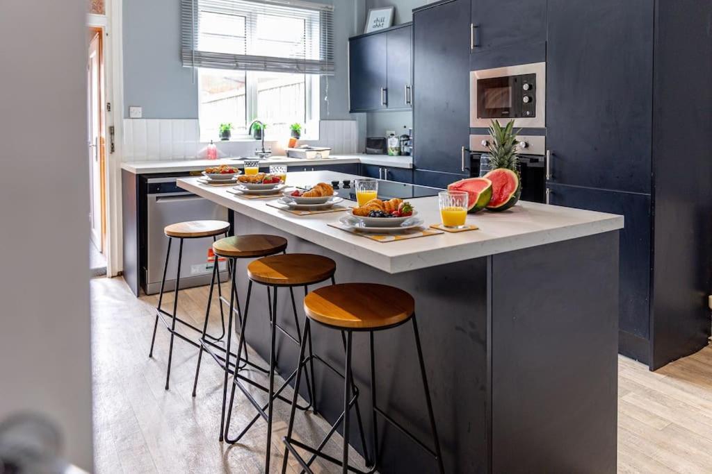 a kitchen with a island with bar stools at Liquorice Lodge- 2 bed & parking in Castleford