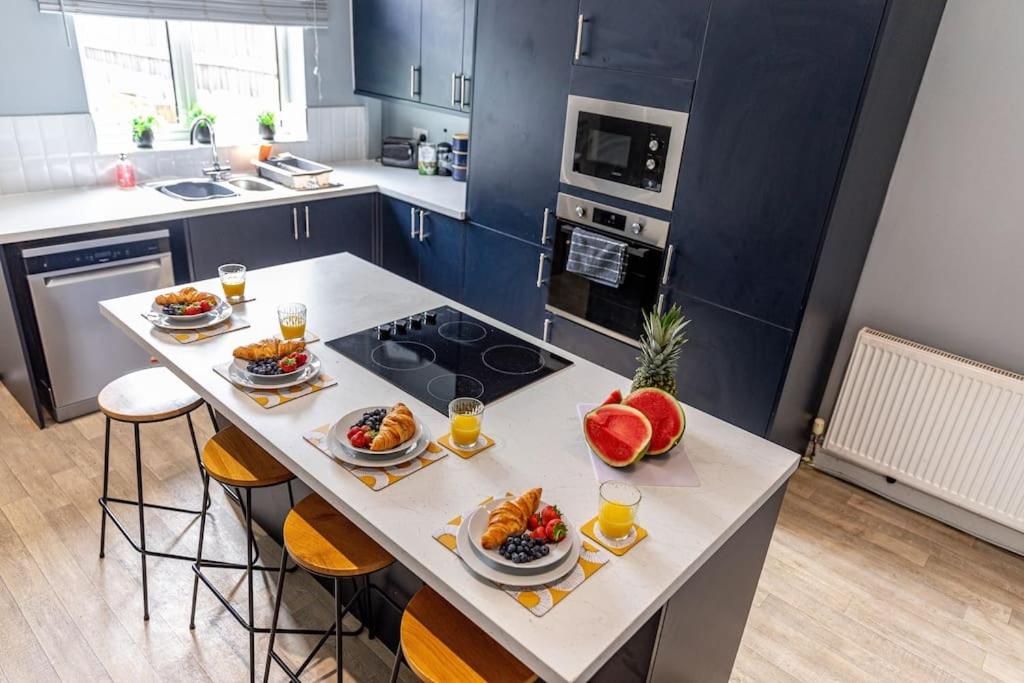 a kitchen with a table with plates of food on it at Liquorice Lodge- 2 bed & parking in Castleford