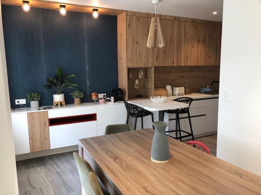 une cuisine et une salle à manger avec une table et des chaises dans l'établissement Maison de famille rénovée - Larmor centre bourg, à Larmor-Plage