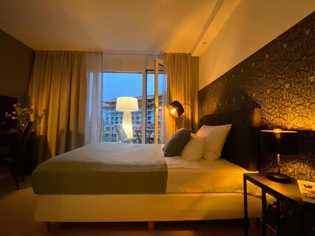 a bedroom with a large bed and a balcony at Paragon Apartments in Frankfurt