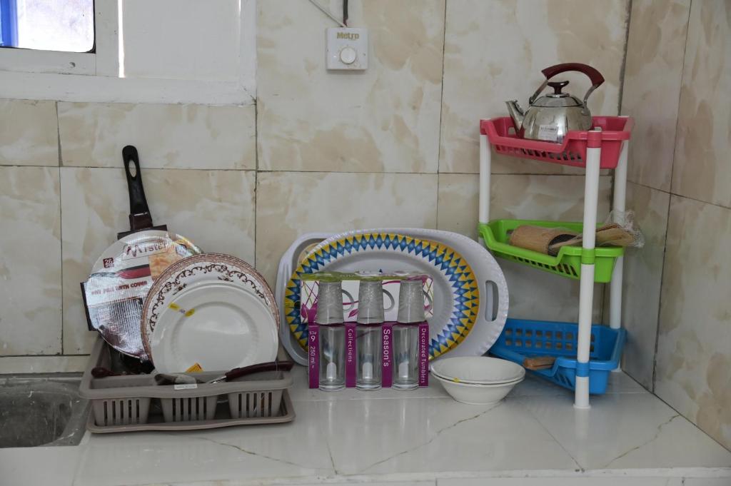 a kitchen counter with plates and other dishes on a shelf at New Furnished Apartment in Djibouti