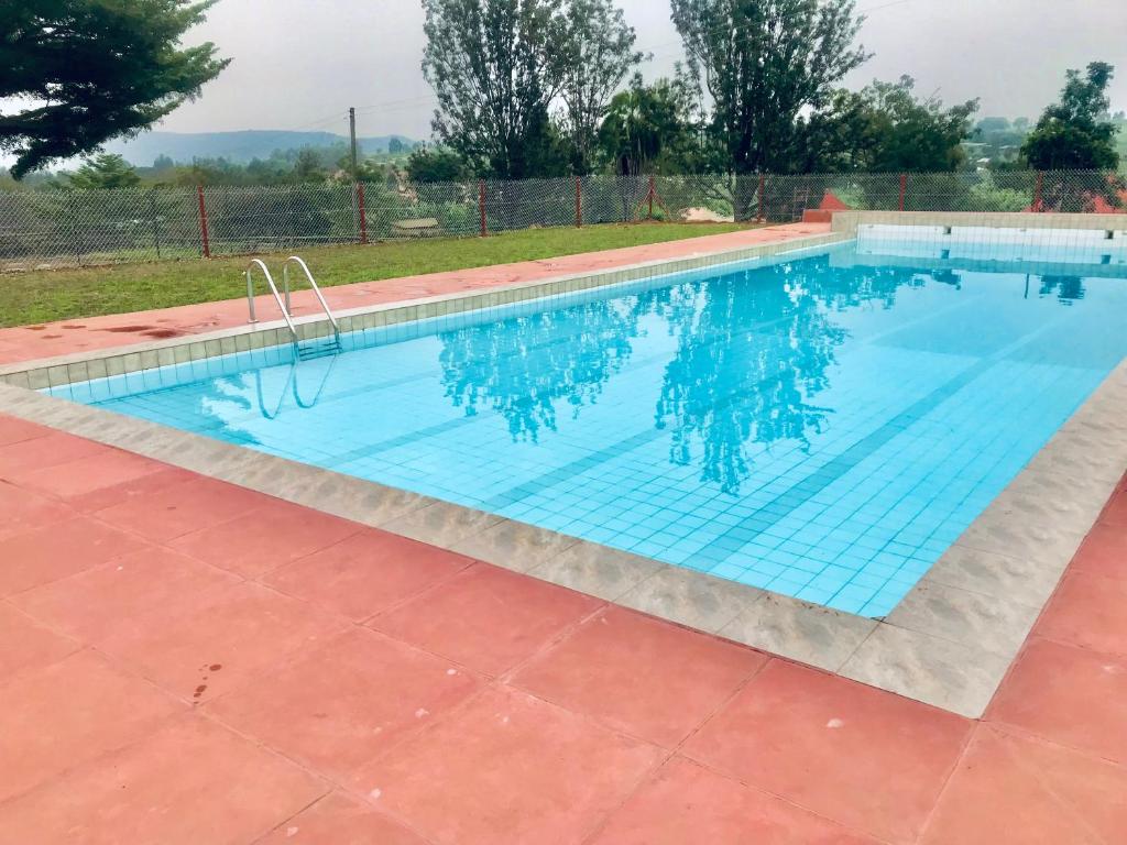 Mbarara的住宿－Rwekishokye Country Club，一座大型游泳池,铺有瓷砖地板,享有蓝色的海水