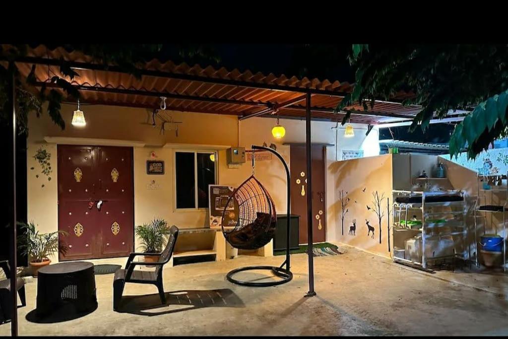 バンガロールにあるSattva Farmstayの椅子とテニスラケット付きの部屋