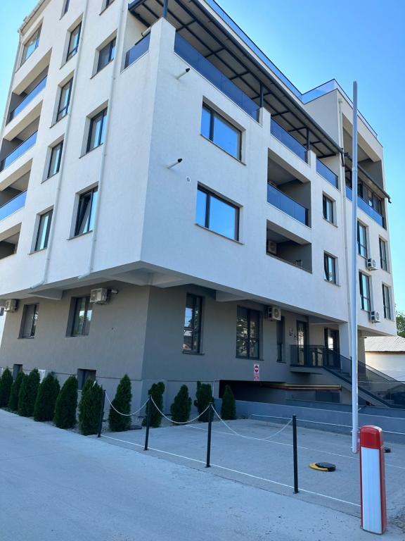 a white building with a tennis court in front of it at Stadium Central Apartment Residence & terrace in Craiova