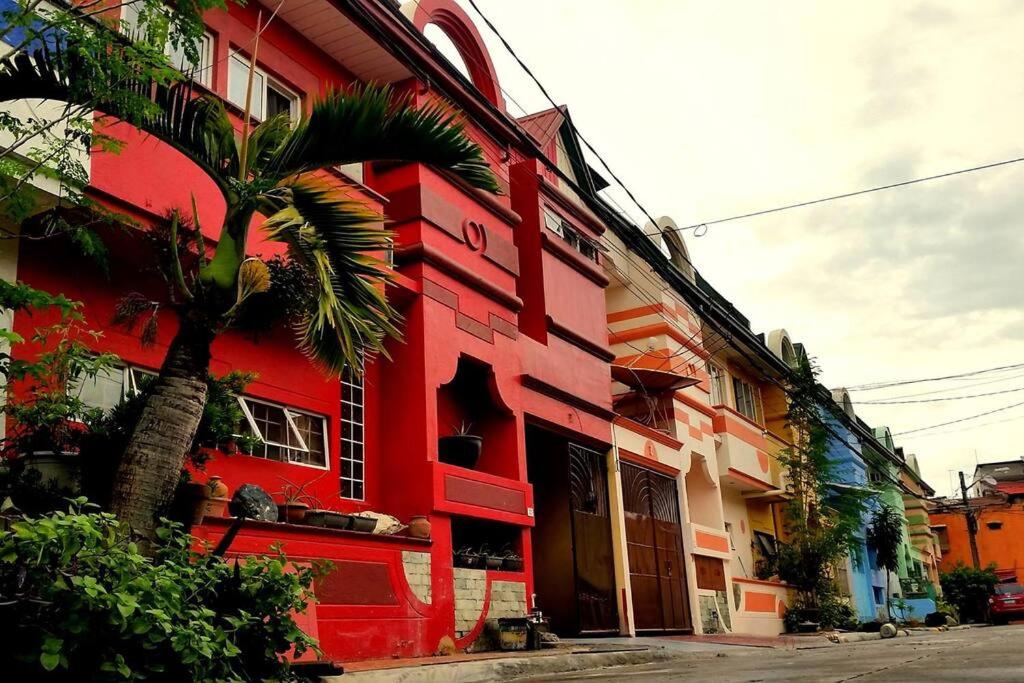 un edificio rojo con una palmera delante en Home Near Airport & MOA for Big Family Groups, en Manila