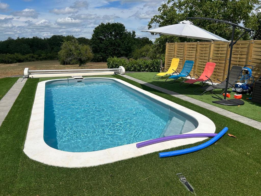 - une piscine avec 2 chaises longues et un parasol dans l'établissement La Maison d'Augustin en Périgord, à Limeyrat
