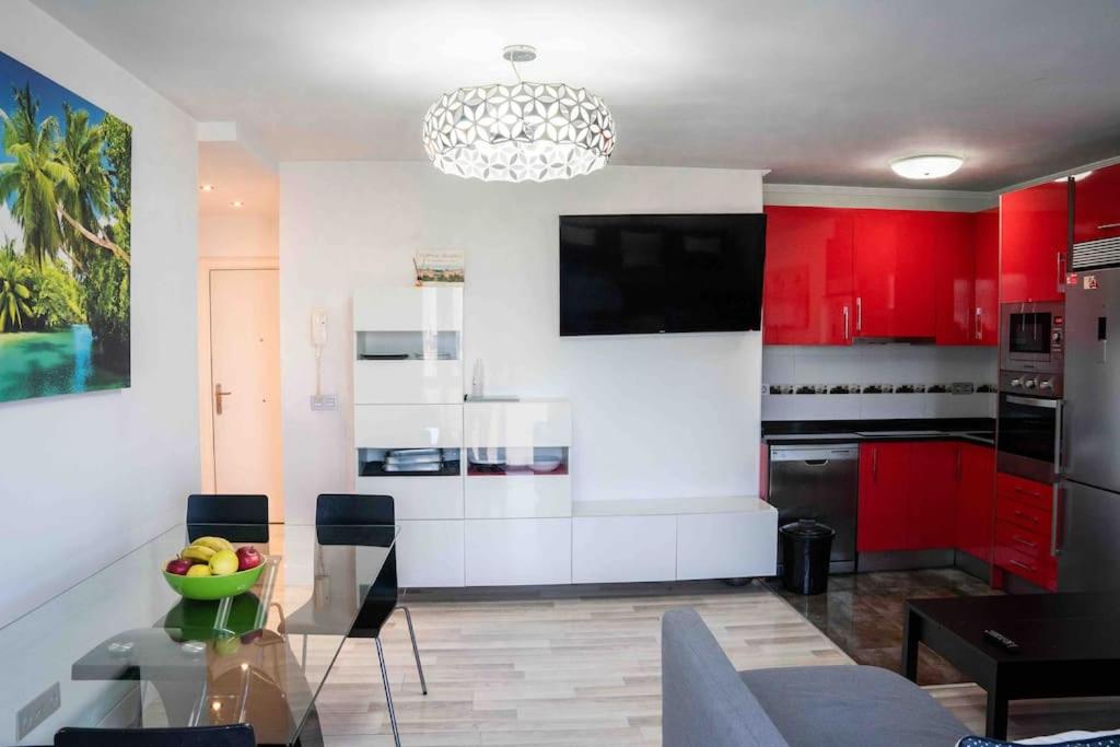 a kitchen with red cabinets and a glass table at La bona vida Vitoria in Arriaga