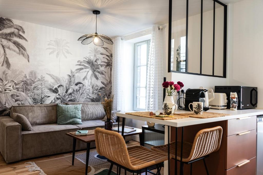 uma cozinha e sala de estar com um sofá e uma mesa em Le grand Arth&M Clermont Ferrand em Clermont-Ferrand