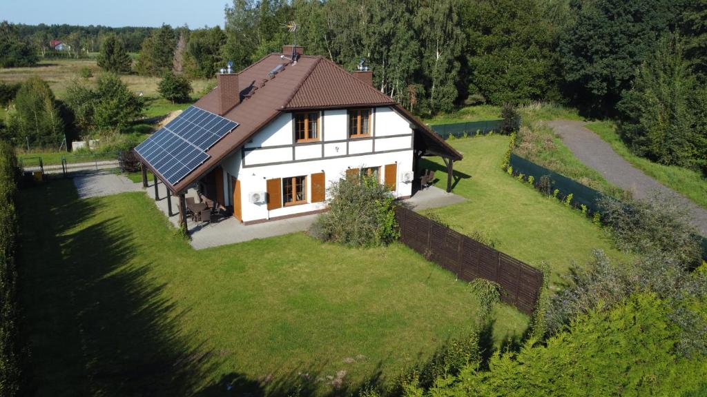 a house with a lot of solar panels on the grass at Dom w Rusinowie in Rusinowo