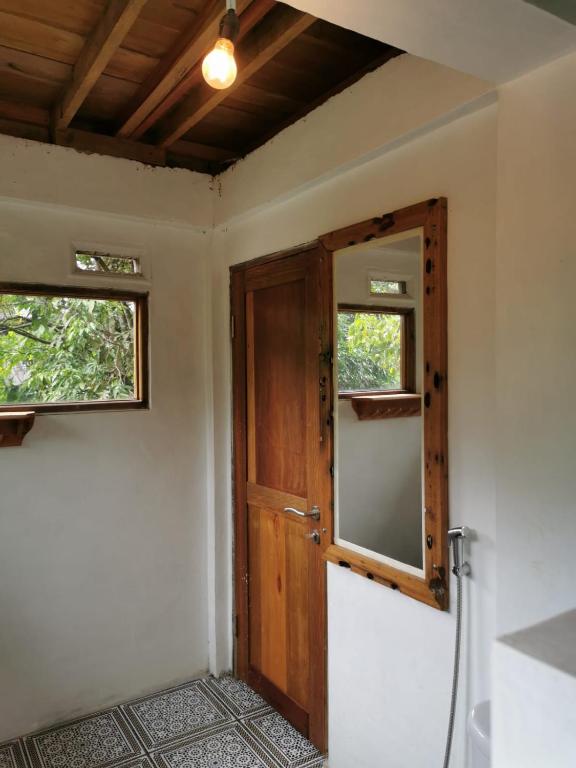 an empty room with a door and a window at Rambai Tree Jungle Lodges in Bukit Lawang