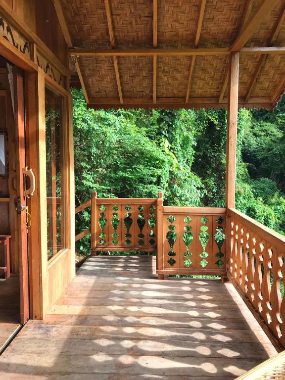 a wooden walkway on a porch of a house at Rambai Tree Jungle Lodges in Bukit Lawang
