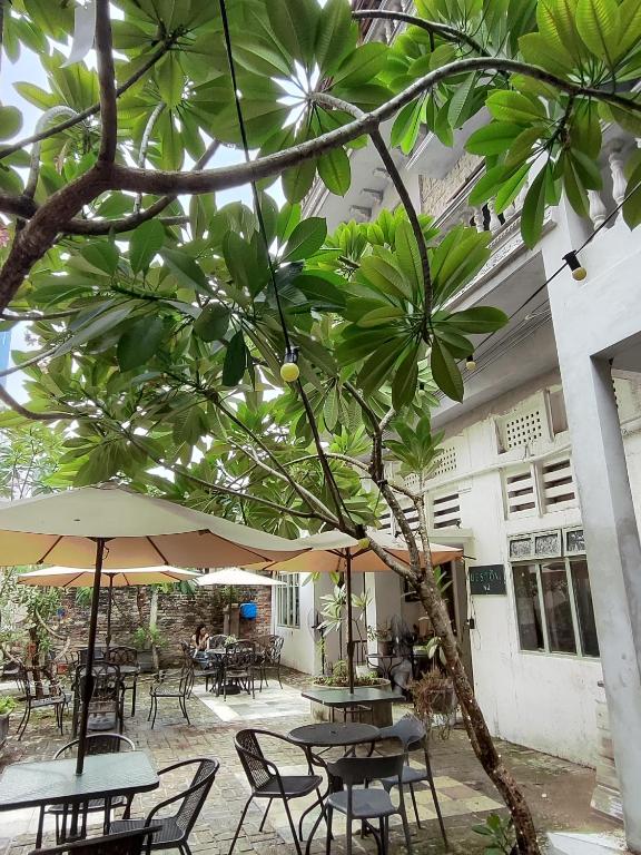 an outdoor patio with tables and chairs and umbrellas at Bestow Boutique Hotel in Kuala Lumpur