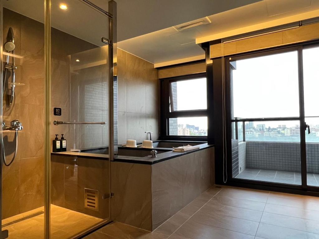ein Bad mit einer Dusche, einem Waschbecken und einem Fenster in der Unterkunft Sunrise Hot Spring House in Toucheng