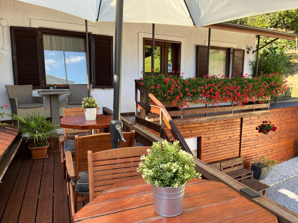 a patio with wooden benches and flowers on a house at Rooms Horvat in Krapina