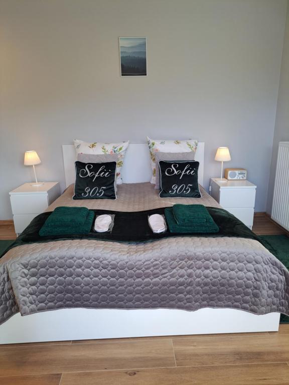 1 dormitorio con 1 cama grande con almohadas verdes en Rubus 305 Sofii en Świnoujście