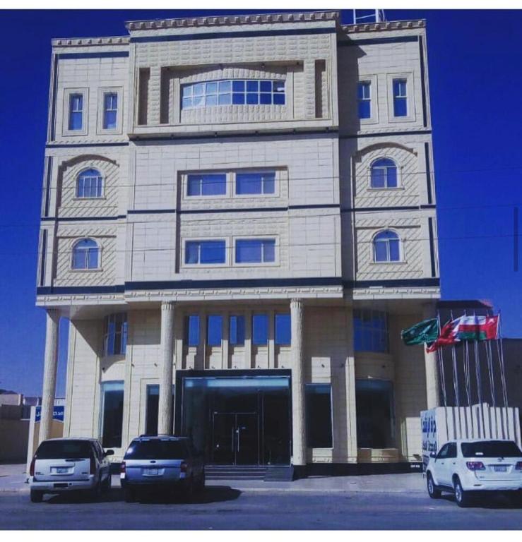 een gebouw waar auto's voor geparkeerd staan bij درة الراشد للشقق المخدومة in Hafr Al Baten