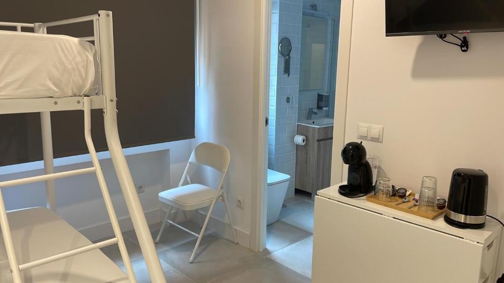 マドリードにあるC7 Exclusiva zona Madridの二段ベッド1組、バスルームが備わる小さな客室です。