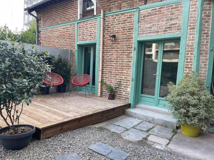 eine Holzterrasse mit zwei Stühlen auf einem Haus in der Unterkunft Maison du Thabor in Rennes