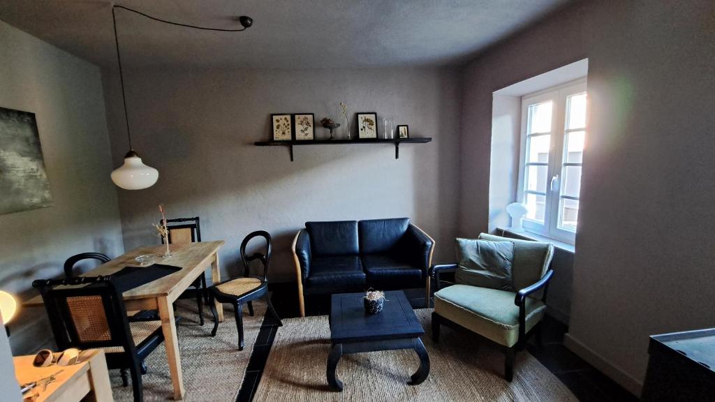 ein Wohnzimmer mit Stühlen, einem Tisch und einem Fenster in der Unterkunft Ferienhaus Fridolin in Zell an der Mosel