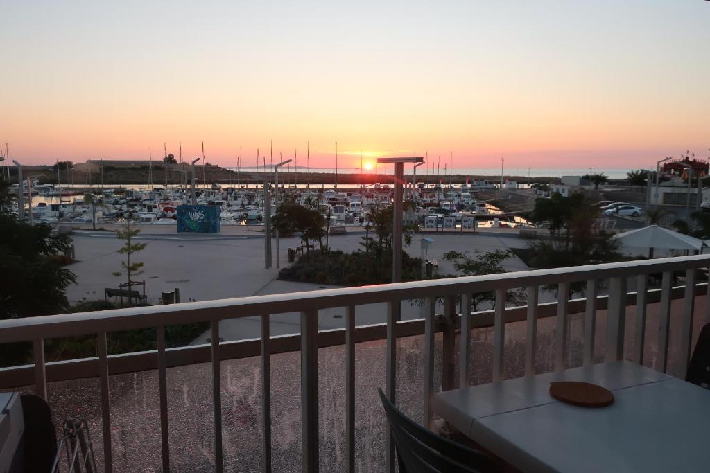 d'un balcon offrant une vue sur le port de plaisance au coucher du soleil. dans l'établissement Studio Valras Vue port et mer, à Valras-Plage