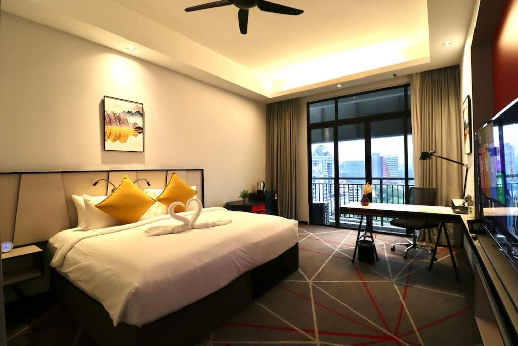 a bedroom with a bed and a desk and a television at M101 KLCC KL city King Suites by GoPlus in Kuala Lumpur